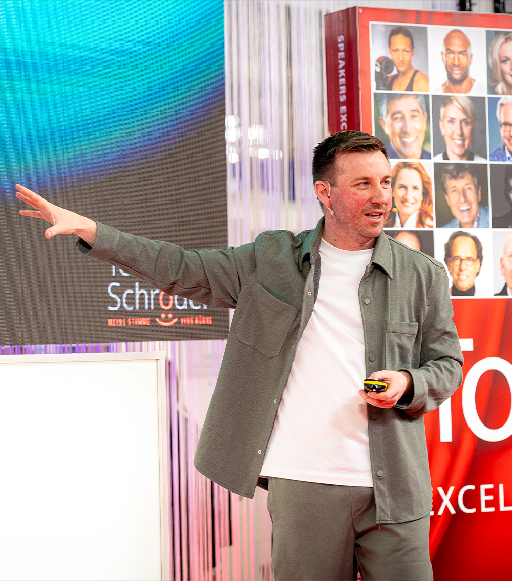 Torsten Schröder hält seine Keynote und zeigt dabei auf sein begleitendes Bildmaterial